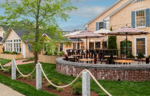 Outdoor Dining Patio with Brick Wall at Edgartown, MA hotel with Tables, Chairs and Umbrellas