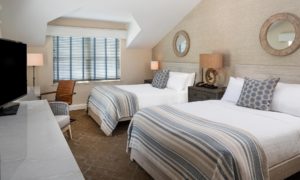 Two Queen Beds in Edgartown, MA Accommodations with Tan Walls, White Linens and Blue and Tan Striped Blanket