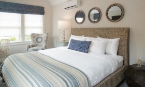 Deluxe King room in Edgartown, Martha's Vineyard with Vaulted Ceilings, Seagrass Bed Frame, White Linens and an Easy Chair